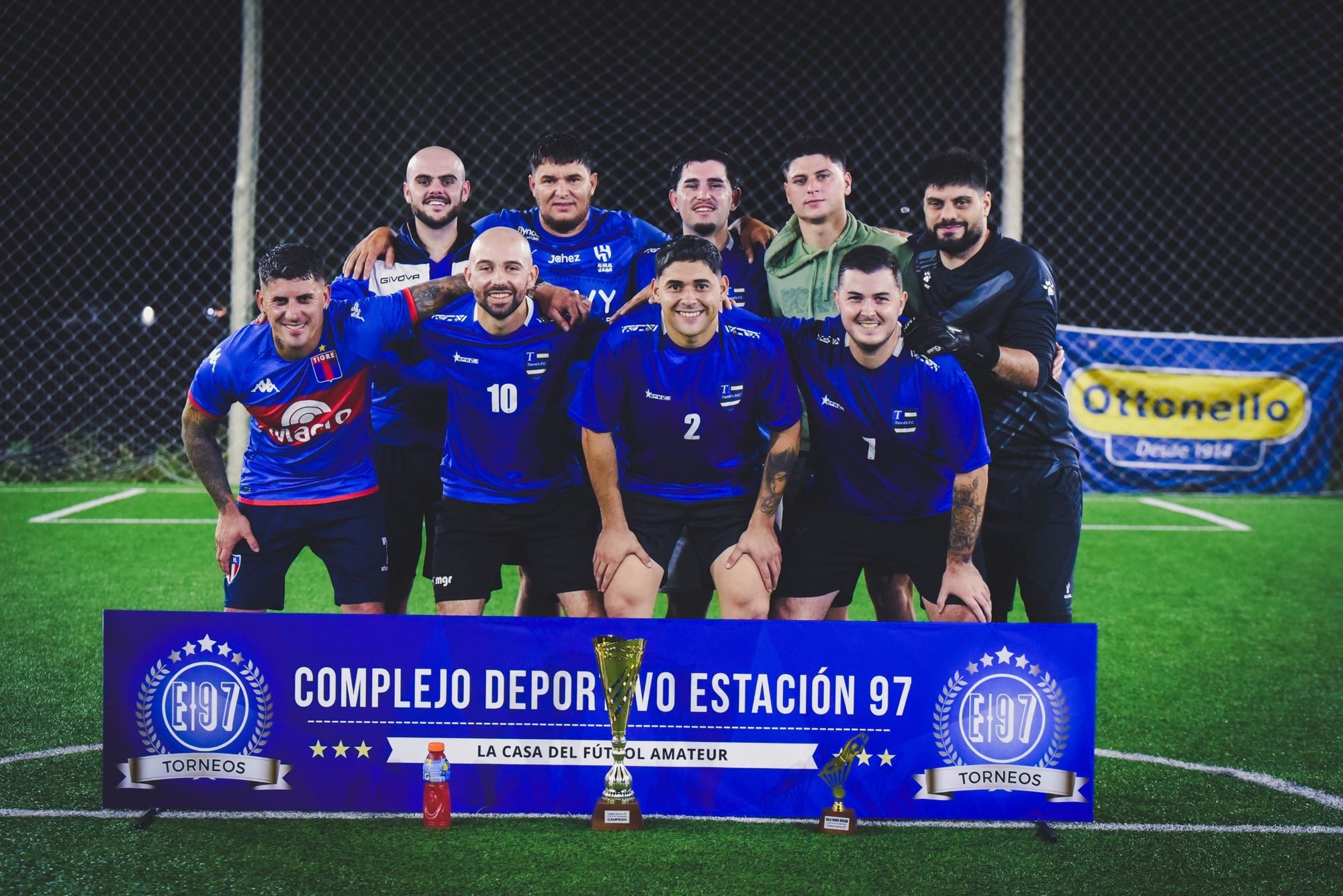 Trofeos frente al cartel del Complejo Deportivo Estación 97